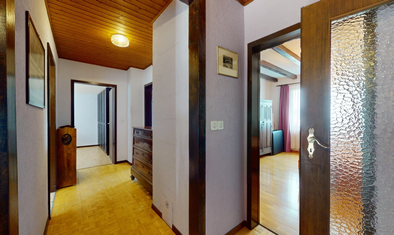 couloir avec poutres apparentes, lumière naturelle, et plafond de bois
