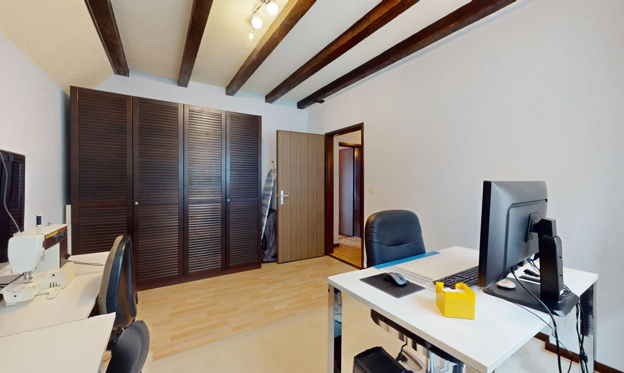 bureau avec poutres apparentes, plancher de bois, et télévision