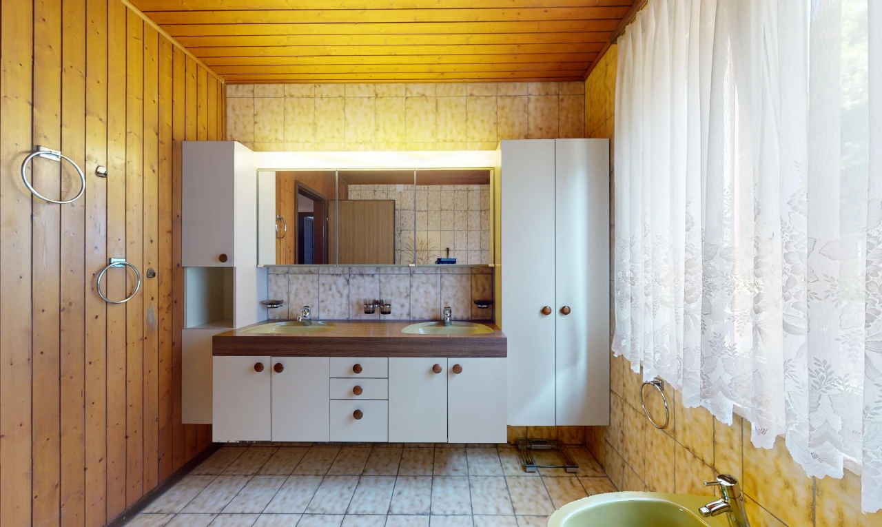 salle de bains avec mur en bois, vasque, miroir, meuble-lavabo, et plafond de bois