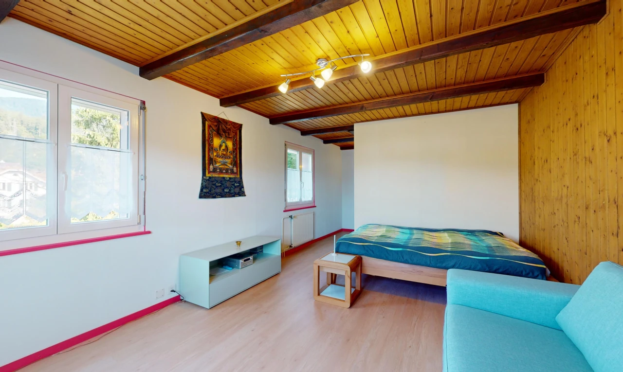 chambre avec radiateur, poutres apparentes, plafond de bois, et lumière naturelle