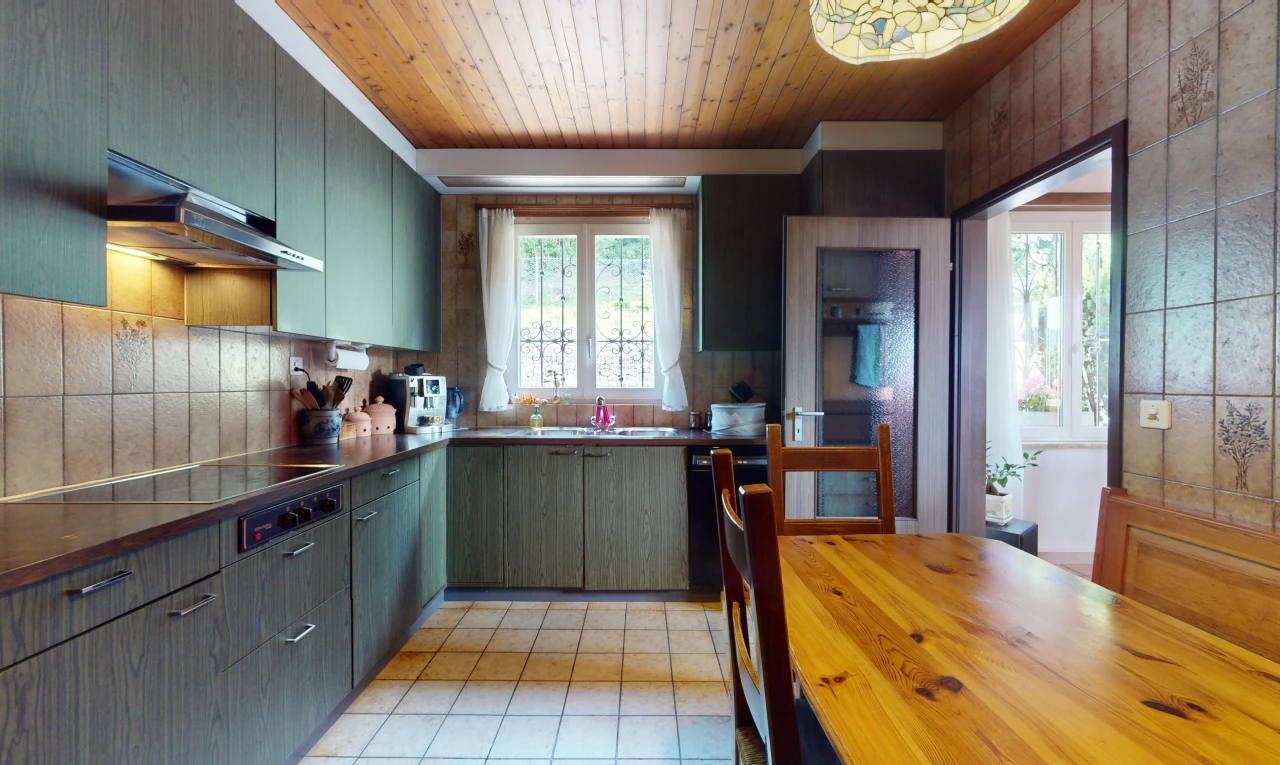 cuisine avec cuisinière, hotte, lumière naturelle, et plafond de bois