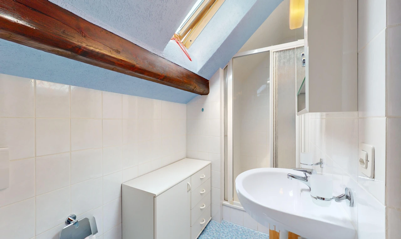 salle de bains avec mur carrelé, douche, plafond en crépis, et plafond voûté