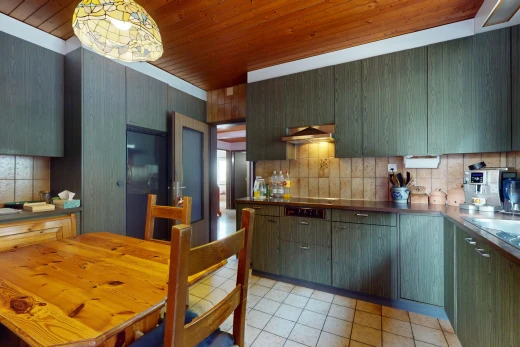 küche mit küchenrückwand beim herd, dunstabzugshaube, pendelleuchte, fliesenboden, und holzdecke