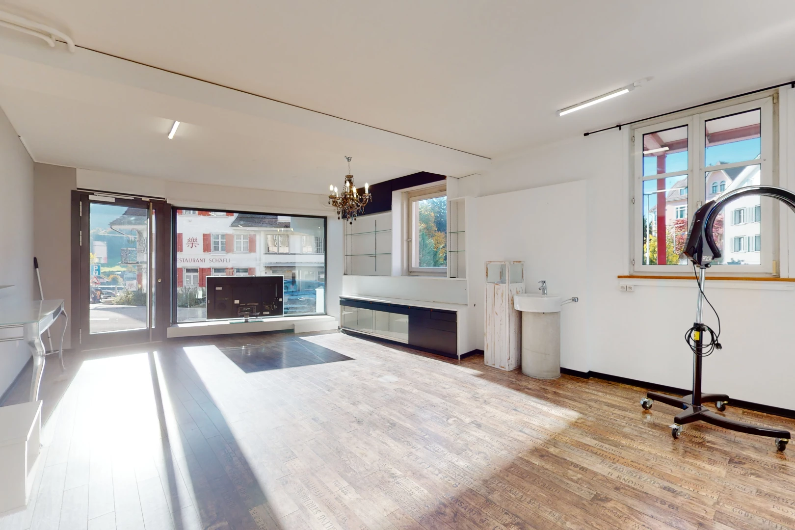 salon avec lustre, parquet, et lumière naturelle