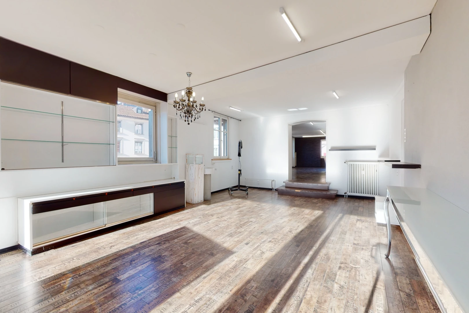 salon avec lustre, parquet, et lumière naturelle