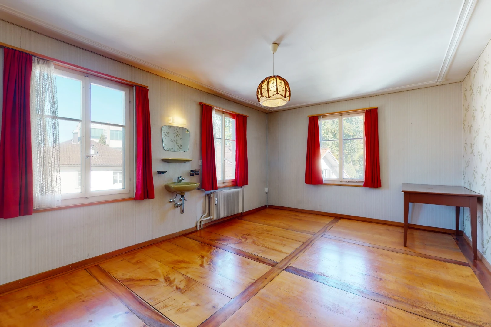 chambre vide avec parquet, lumière naturelle, et radiateur