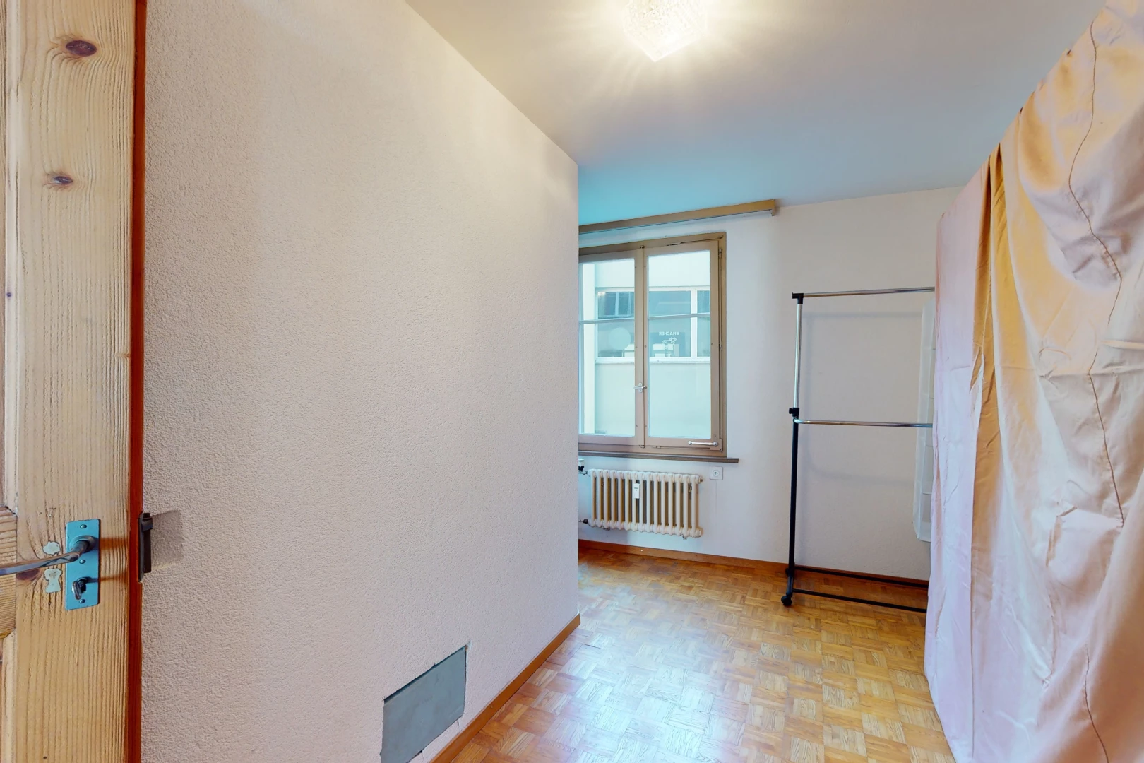 couloir avec lumière naturelle, parquet, et radiateur