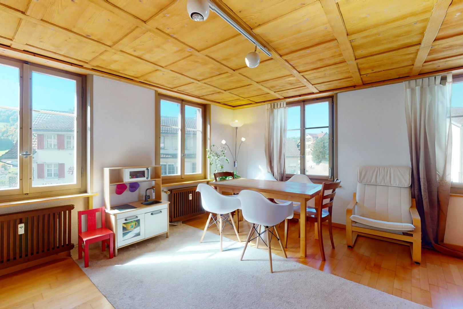 salle à manger avec parquet, lumière naturelle, et radiateur
