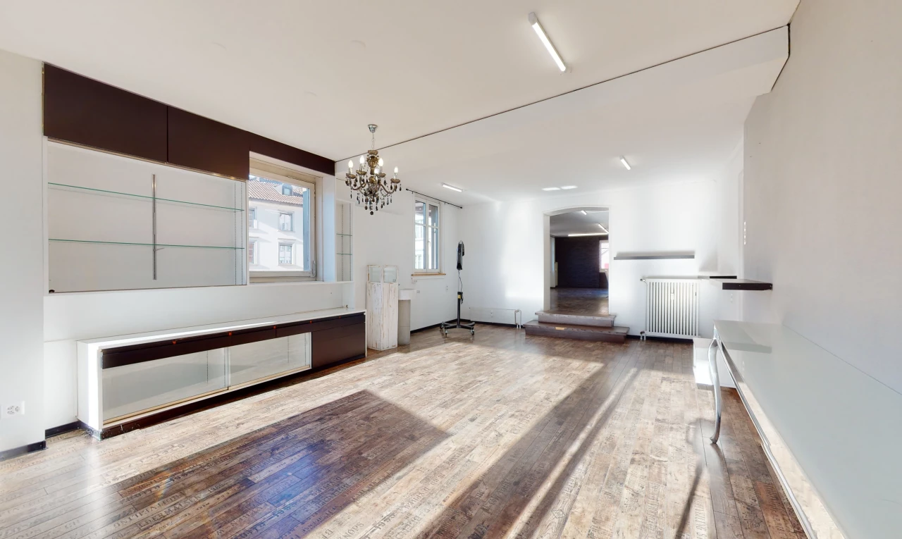 salon avec lustre, parquet, et lumière naturelle