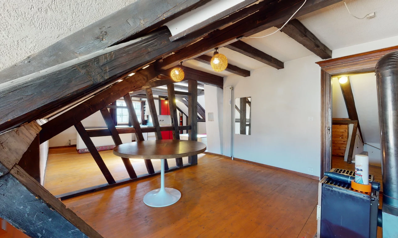 salle à manger avec lumière naturelle et poutres apparentes