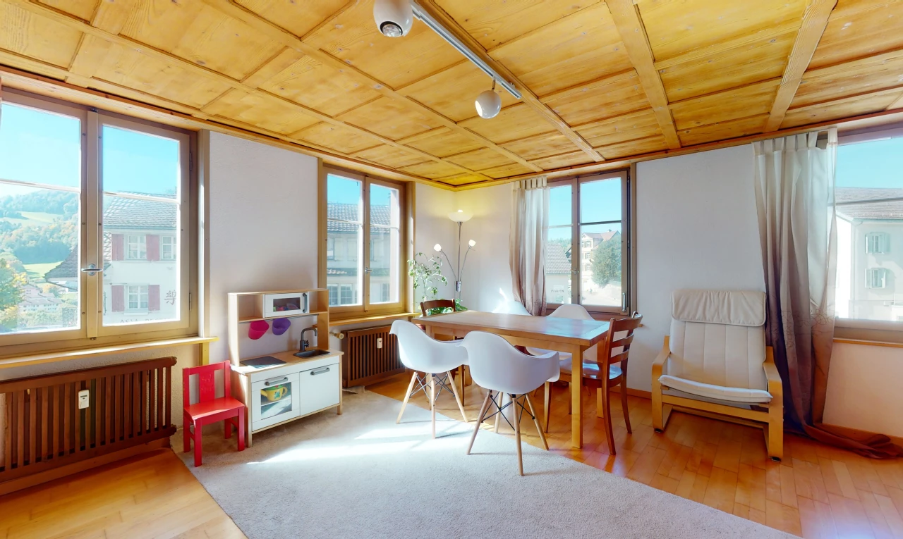 salle à manger avec parquet, lumière naturelle, et radiateur