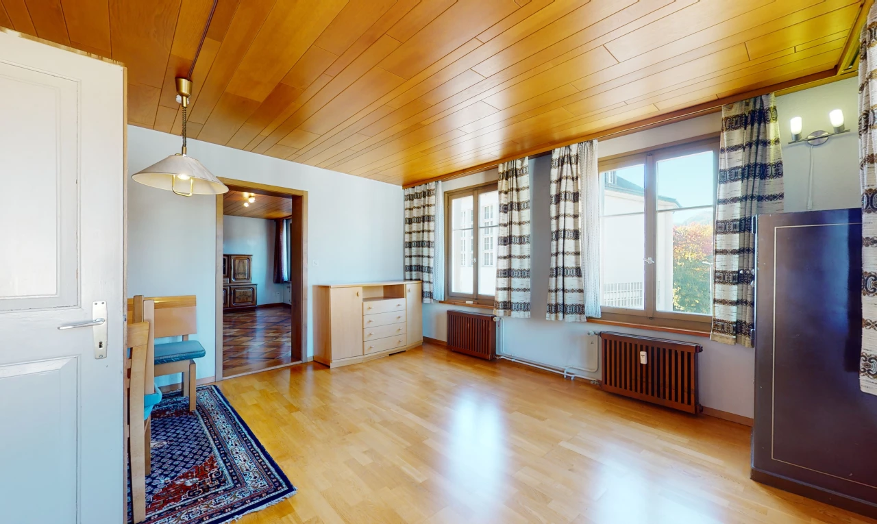 chambre vide avec lumière naturelle, parquet, et radiateur