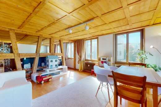 salle à manger avec lumière naturelle, poutres apparentes, parquet, et radiateur