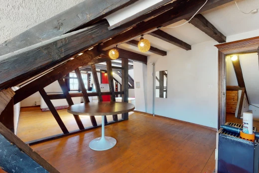 salle à manger avec lumière naturelle et poutres apparentes