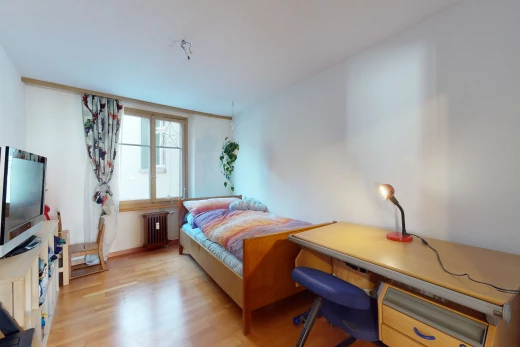 chambre à coucher avec lumière naturelle, parquet, radiateur, et télévision