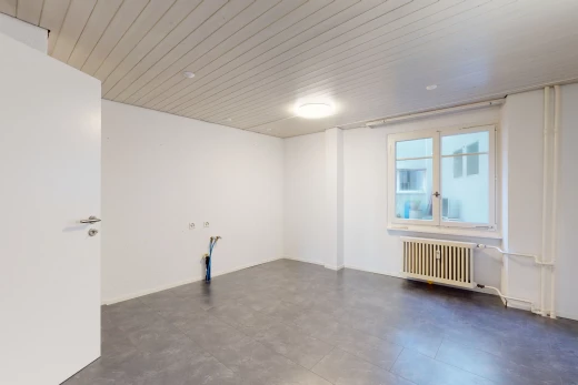 chambre vide avec lumière naturelle, carrelage, et radiateur