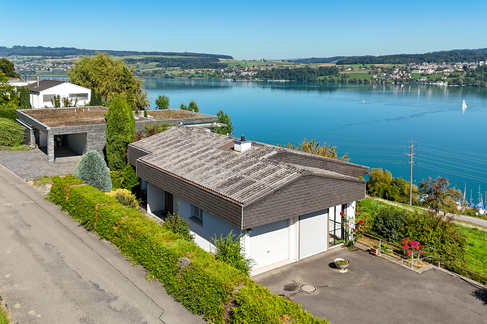 façade avec day time, garage, vue sur l'eau, et water view