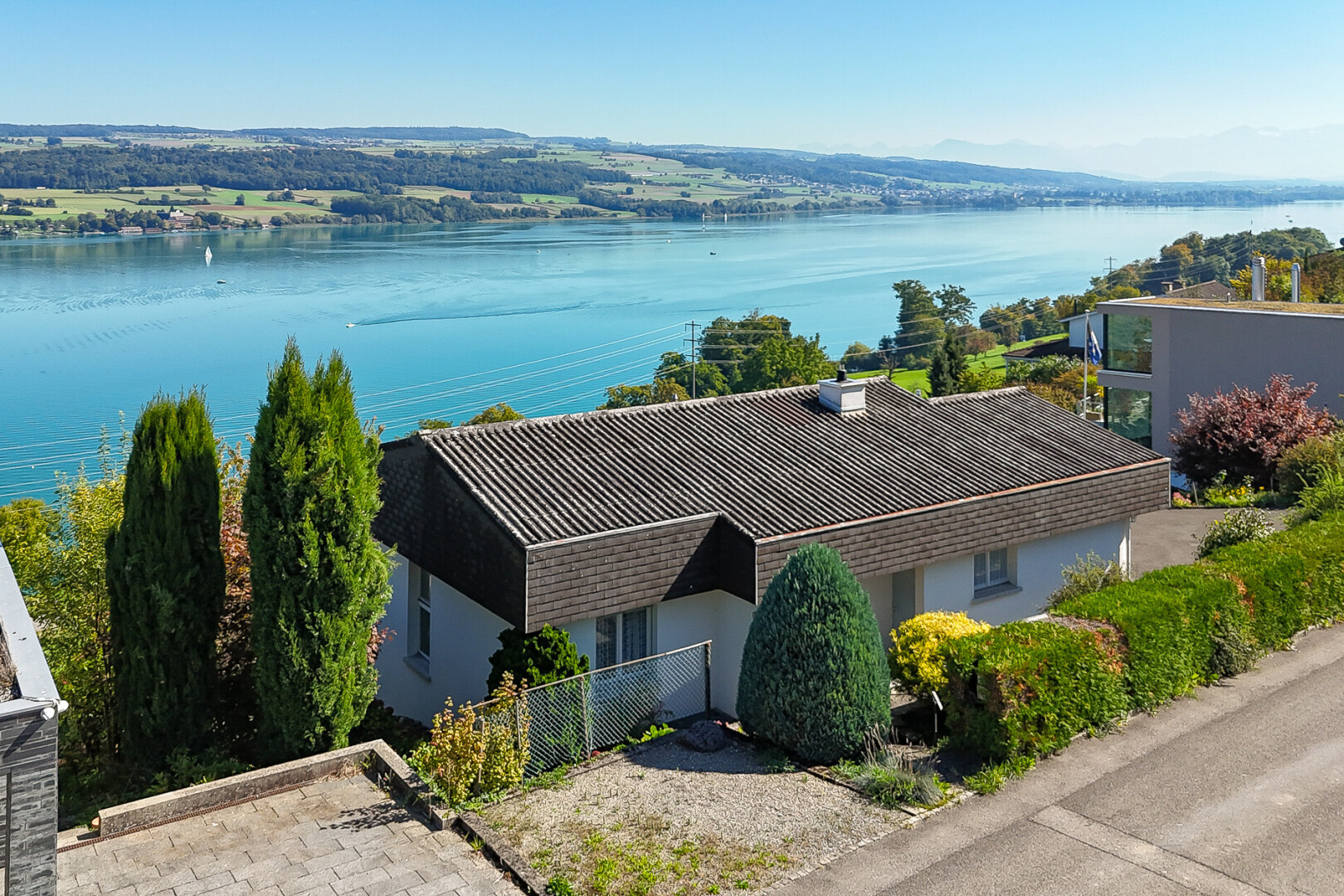façade avec day time, bardage en stuc, clôture, vue sur l'eau, et water view