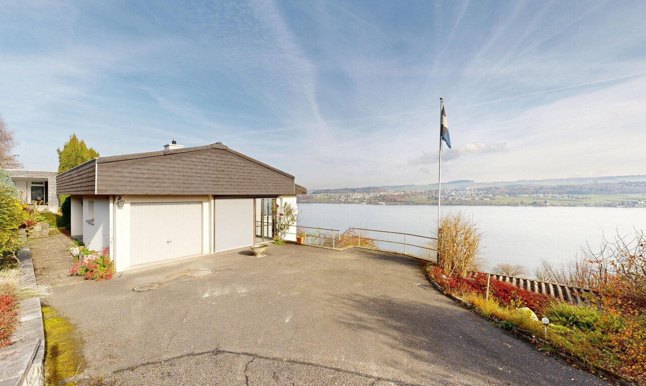 façade avec day time, water view, vue sur l'eau, structure extérieure, et garage détaché