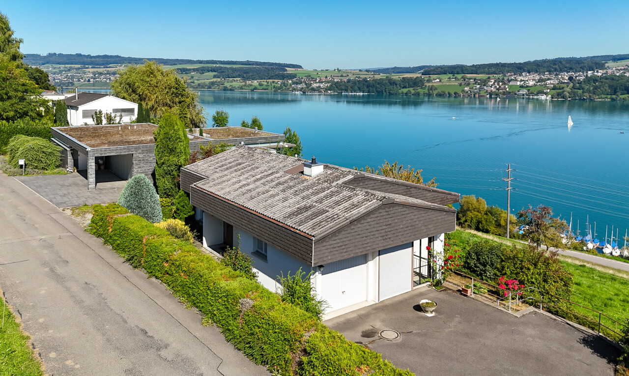 façade avec day time, garage, vue sur l'eau, et water view