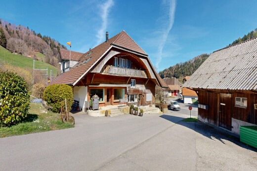 view of home with a balcony, a patio, an outbuilding, and a mountain view