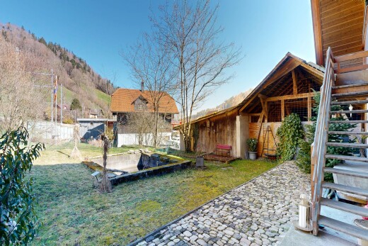outdoor house featuring a lawn, an outdoor structure, and a patio