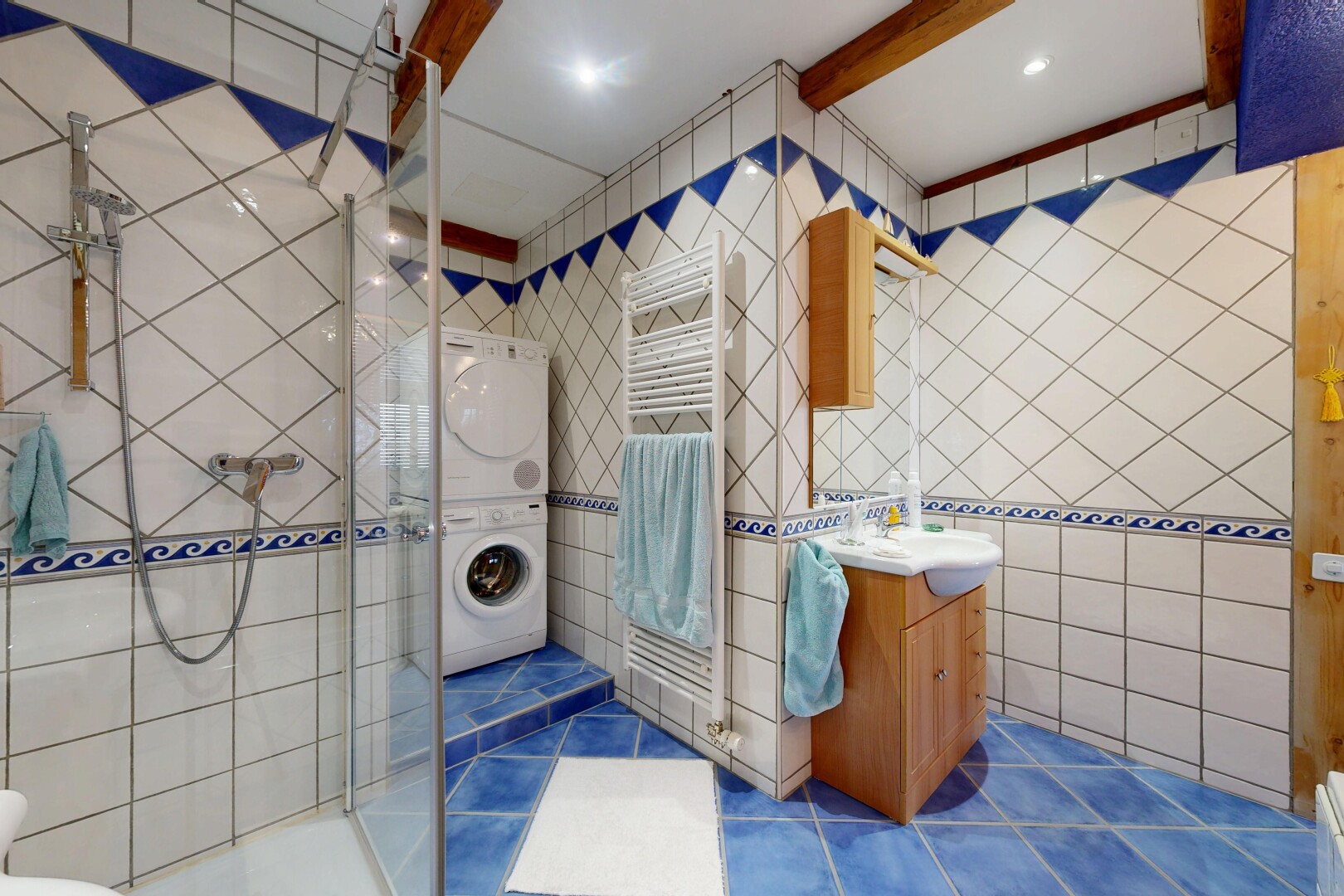 salle de bains avec mur en carrelage, tile wall, lavabo (ou coiffeuse selon le contexte), salle de bain complète, et douche