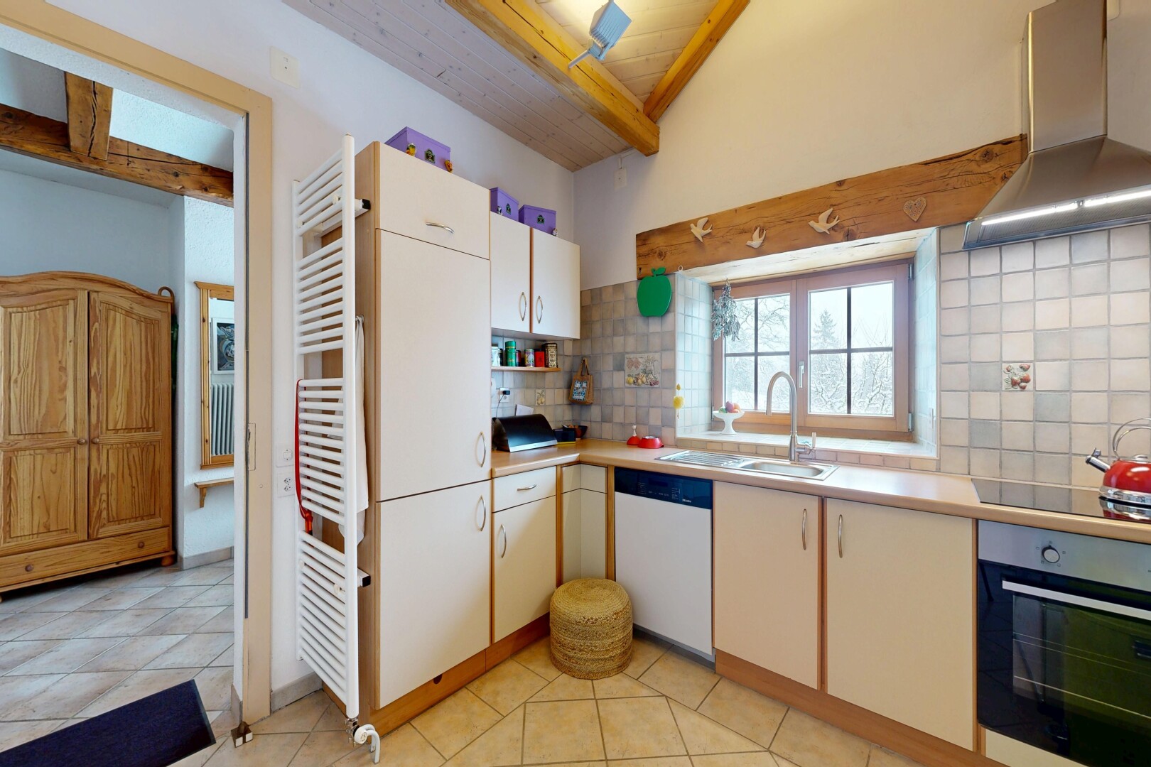 cuisine avec dosseret, backsplash, hotte, four, et plans de travail