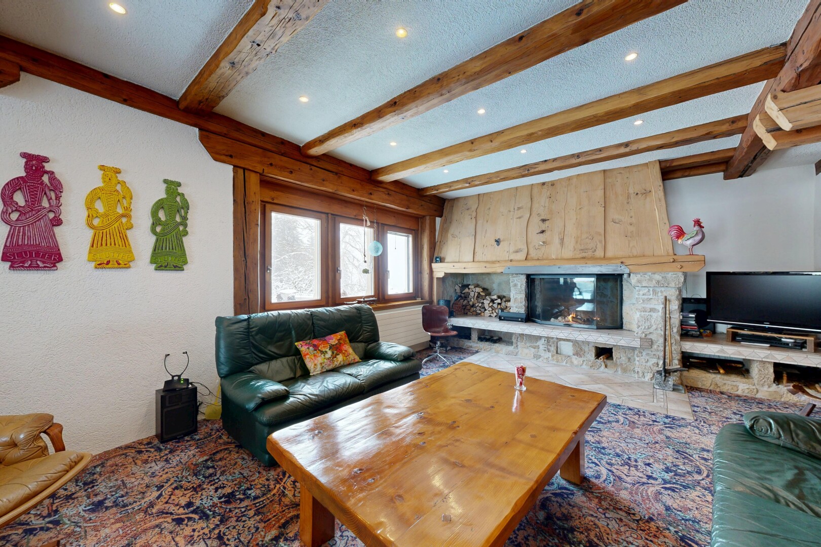 salon avec télévision, lumière naturelle, natural light, inside property, et cheminée