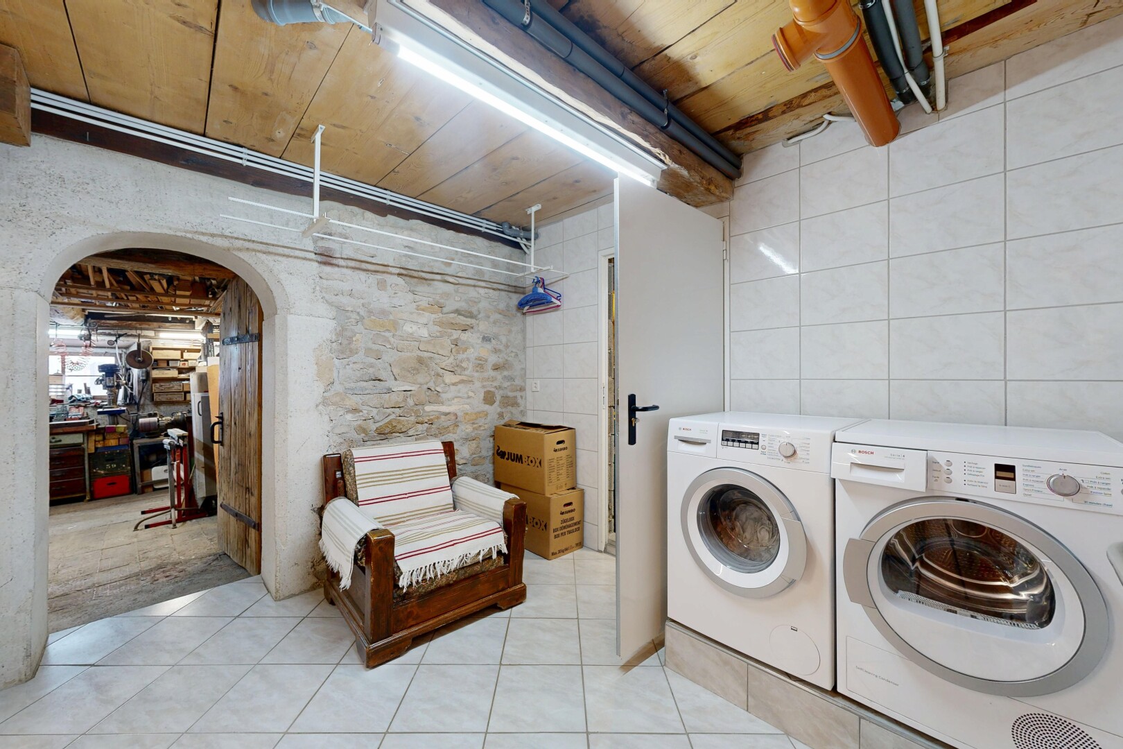 buanderie avec passages en arc, buanderie, light floor, lave-linge et sèche-linge séparés, et wood ceiling