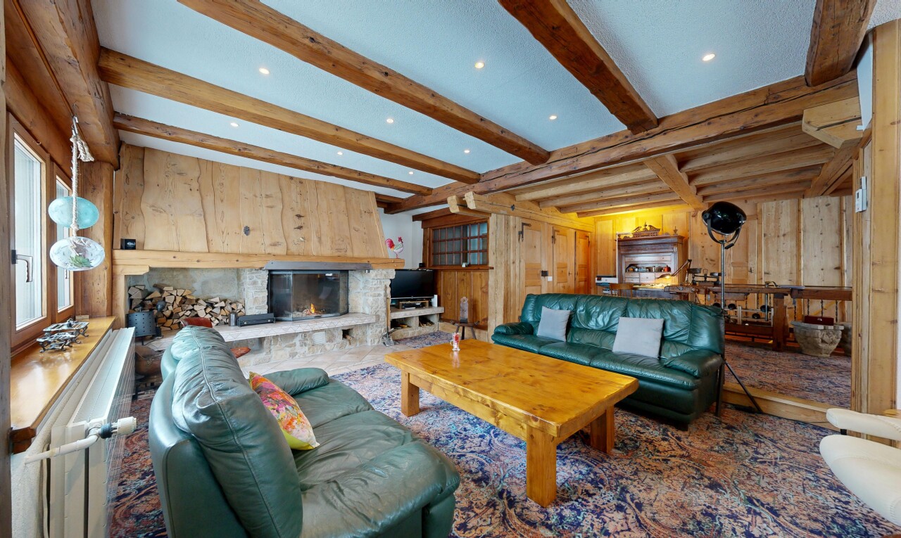 salon avec mur en bois, wood wall, plafond à poutres, beamed ceiling, et cheminée