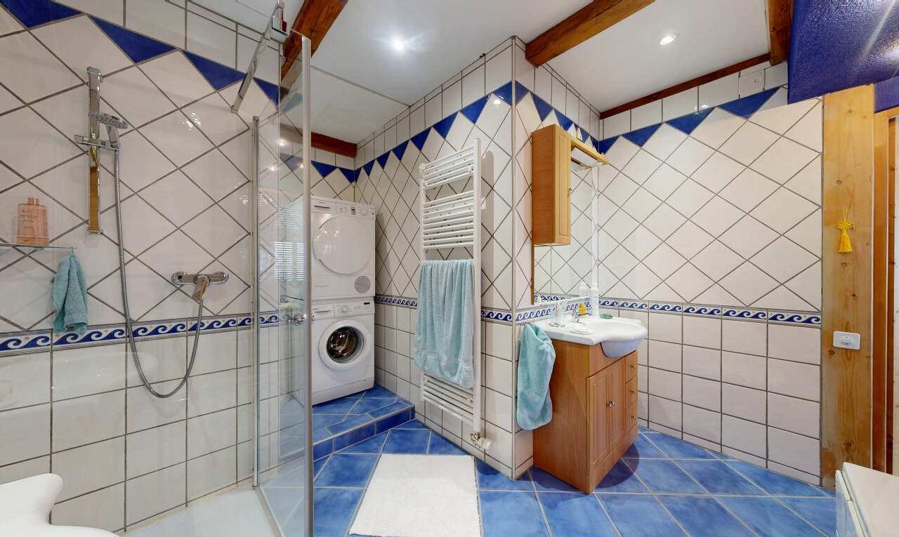 salle de bains avec mur en carrelage, tile wall, lavabo (ou coiffeuse selon le contexte), salle de bain complète, et douche