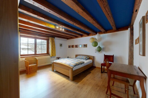 zimmer / schlafzimmer mit inside property, holzfußboden, wood finish floor, balkendecke, und beamed ceiling