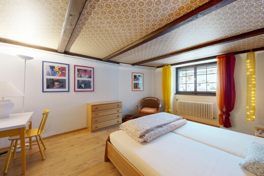 zimmer / schlafzimmer mit wood finish floor, holzfußboden, kühler, inside property, und beamed ceiling