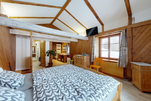 zimmer / schlafzimmer mit inside property, dachschräge, vaulted ceiling, light floor, und fernseher