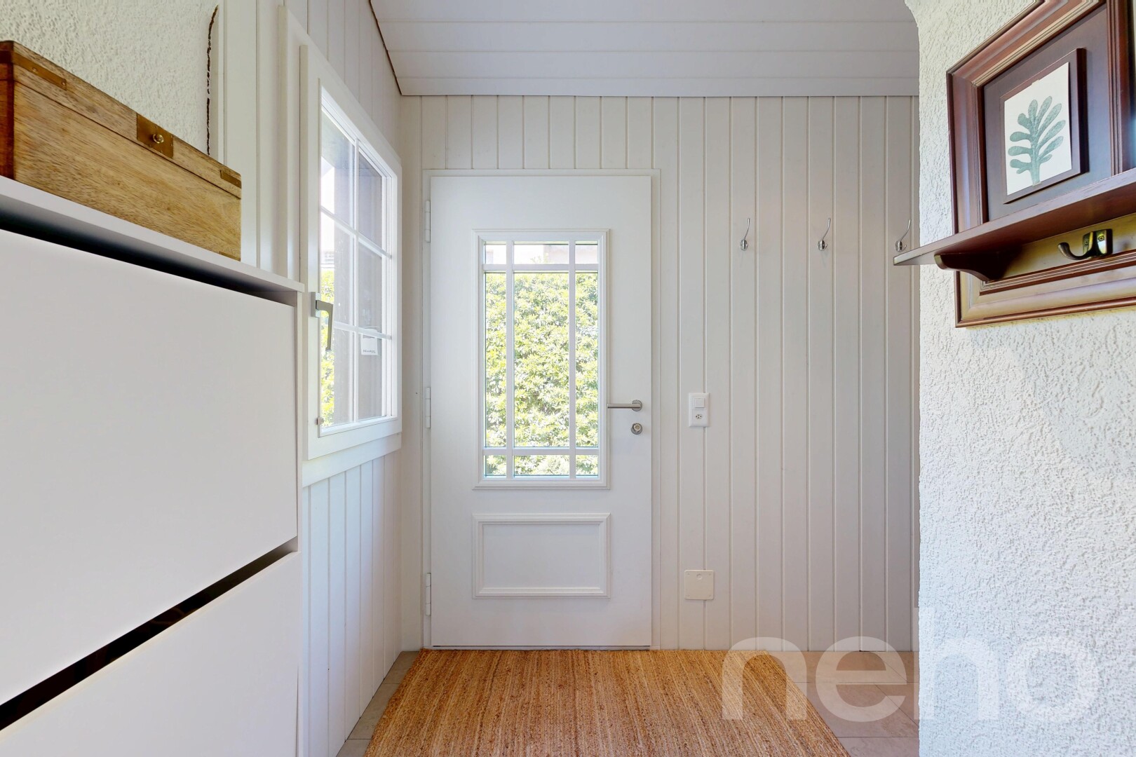 hall with light wood-type flooring and wooden walls