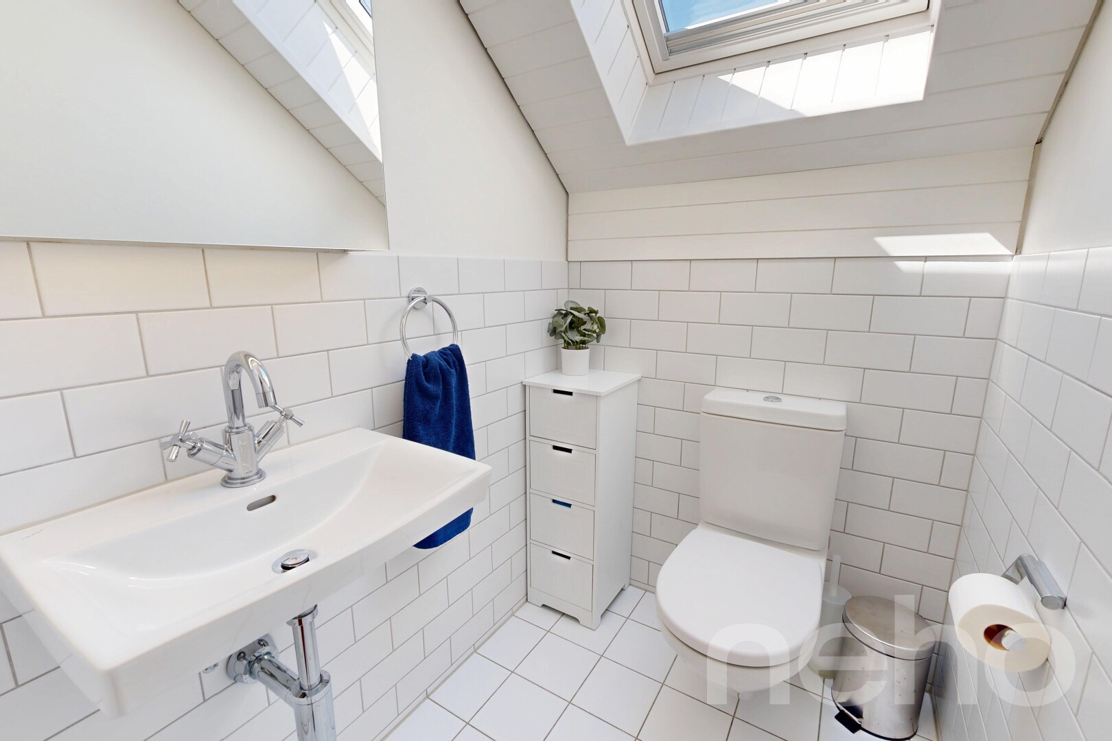 half bathroom with a skylight, vaulted ceiling, tile walls, and light tile patterned floors