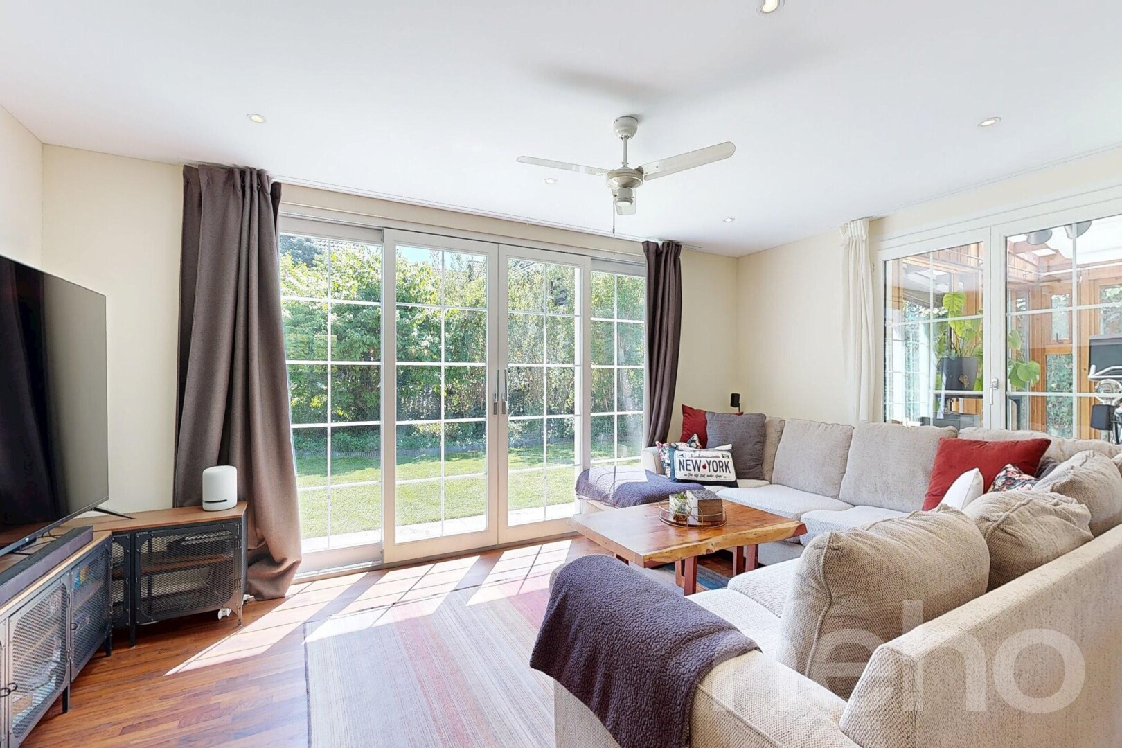 living room featuring ceiling fan, wood finished floors, and healthy amount of natural light
