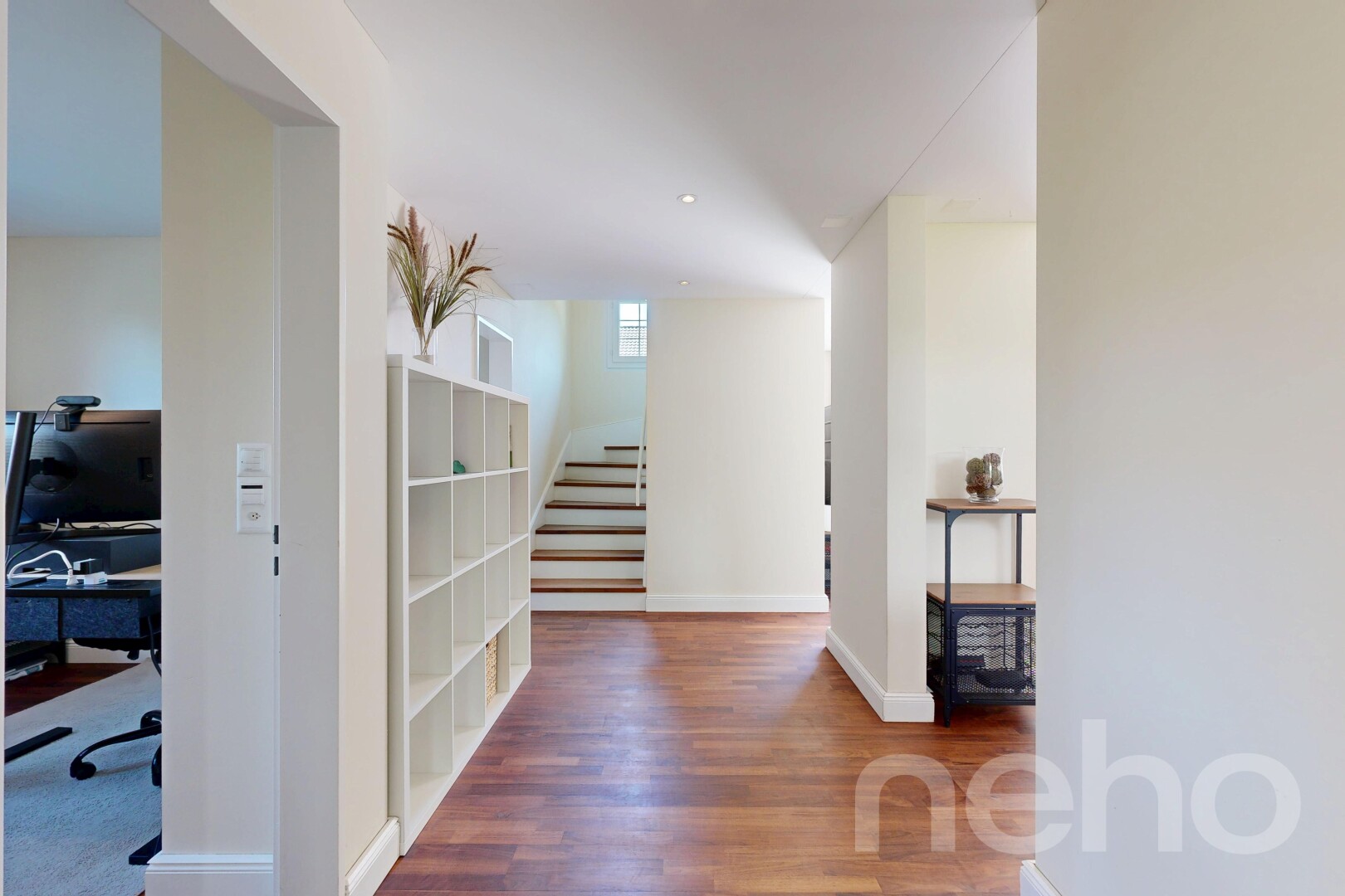 corridor featuring dark wood-style floors and a desk