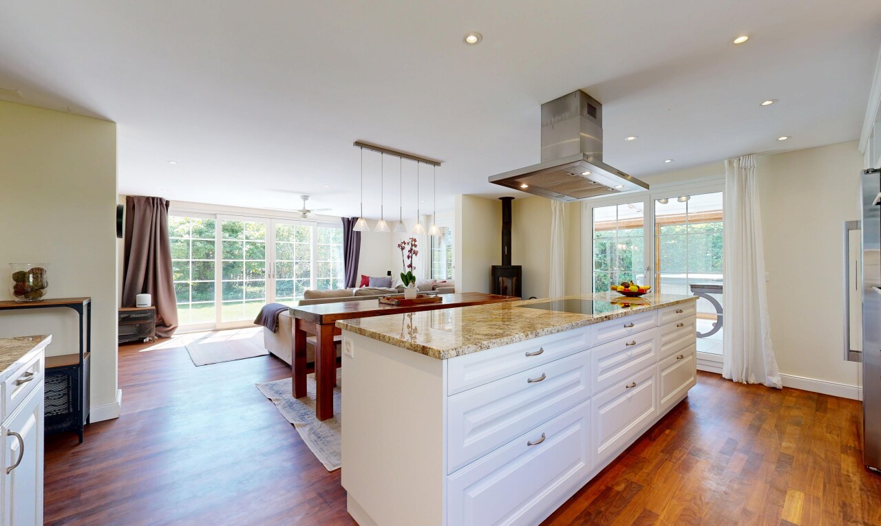 kitchen featuring island range hood, light stone counters, open floor plan, dark wood-style floors, and white cabinets