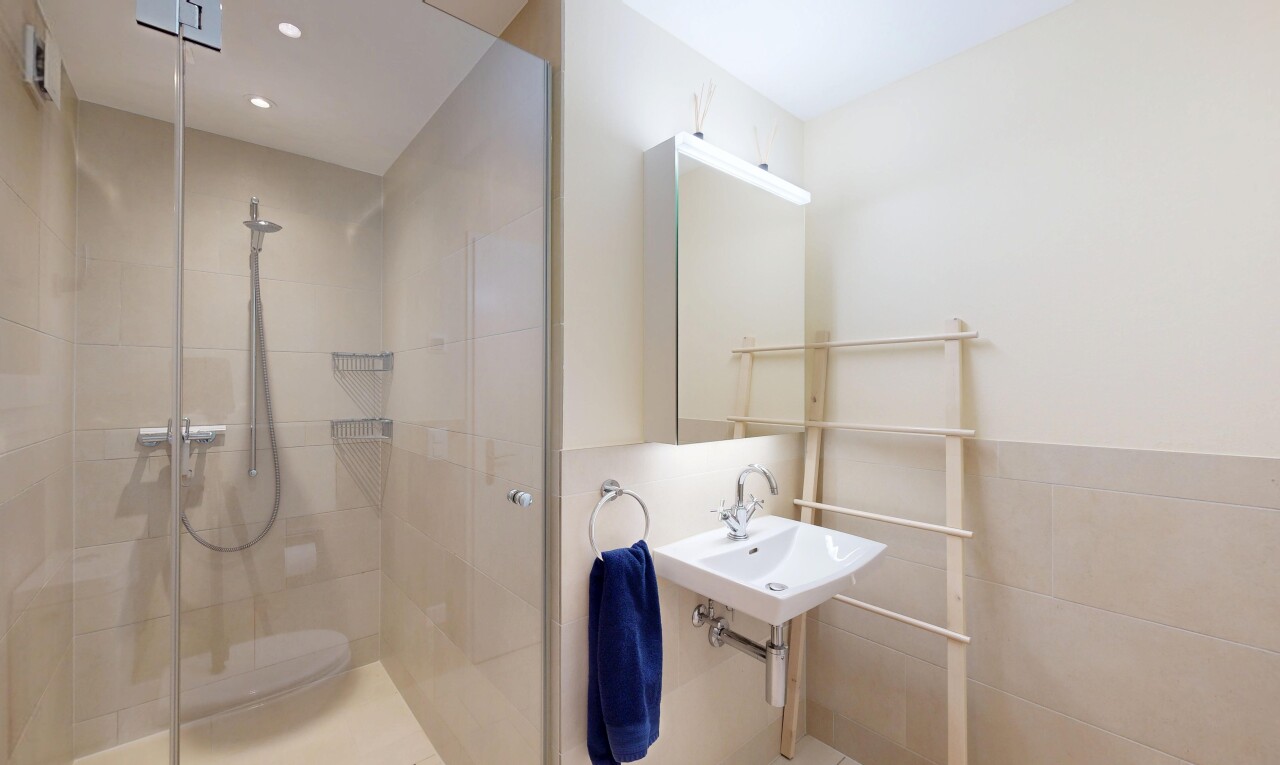 full bathroom featuring a shower stall and tile walls