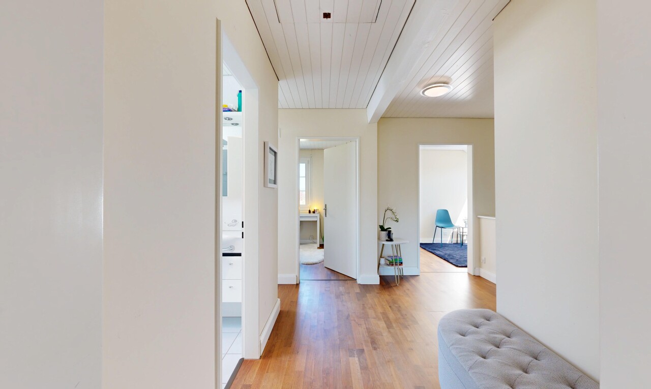 corridor with light wood-style floors and wooden ceiling