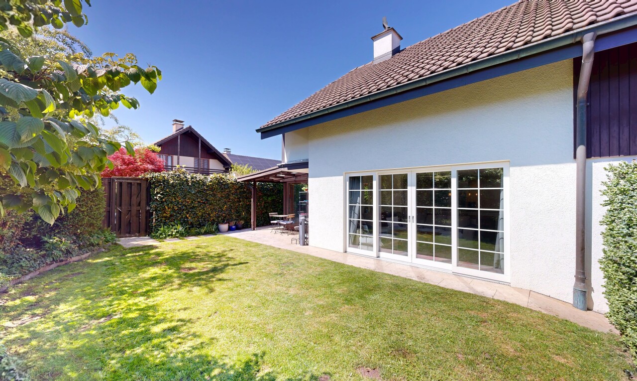 outdoor house with stucco siding, a patio area, a chimney, and a tiled roof