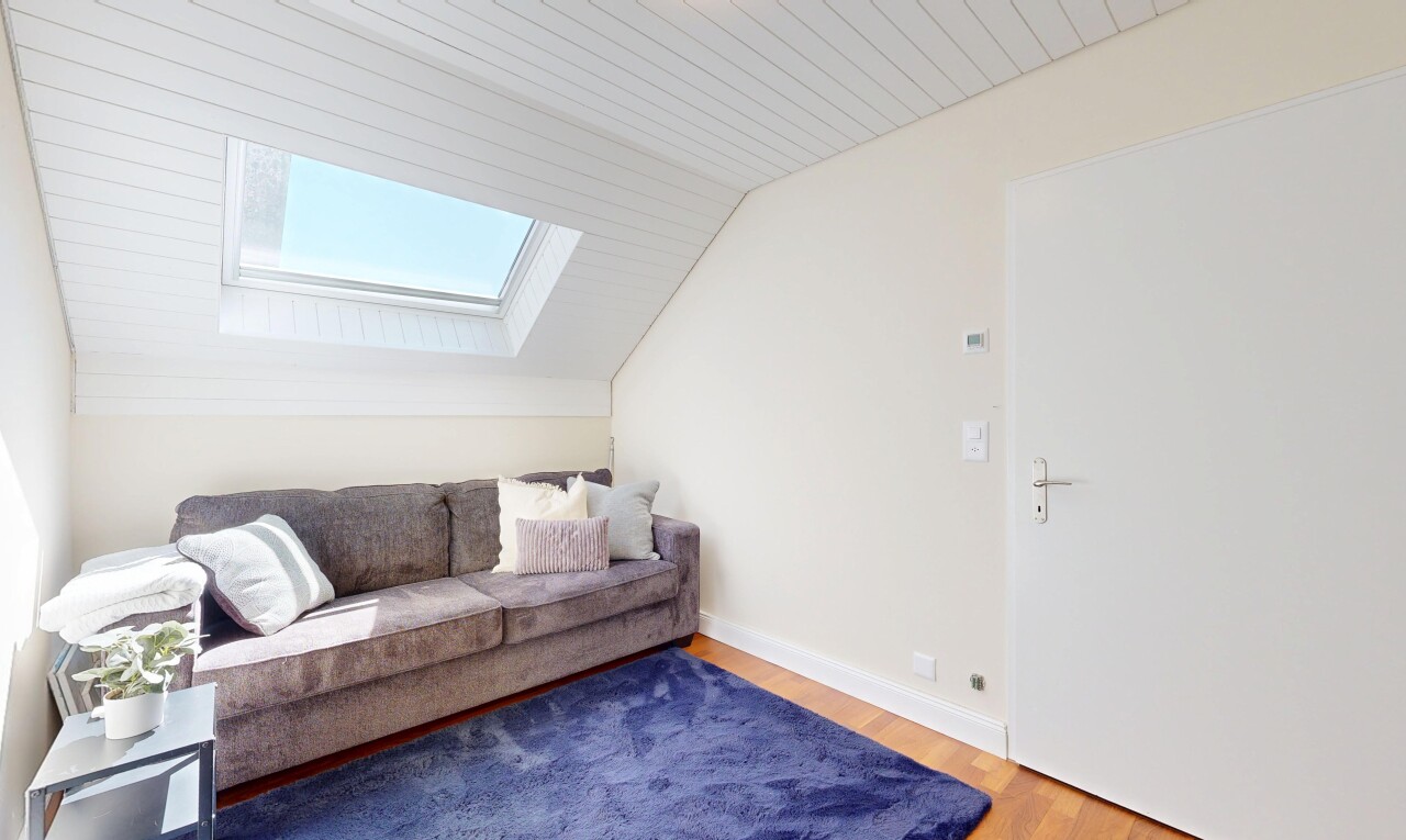 living area with lofted ceiling, wood finished floors, and a skylight