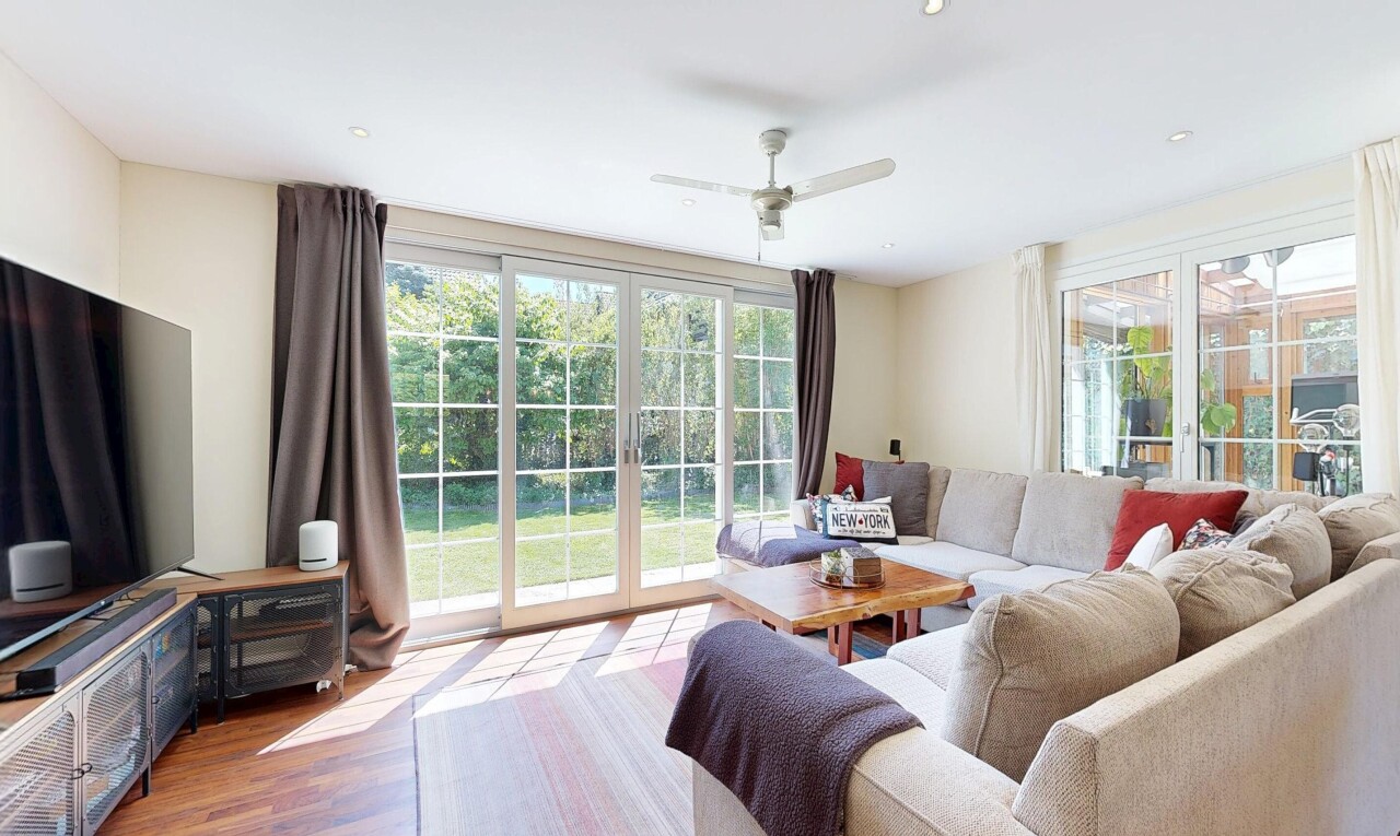 living room featuring ceiling fan, wood finished floors, and healthy amount of natural light
