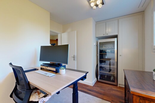bureau avec cave à vin, wood finish floor, sol en finition bois, télévision, et espace bureau