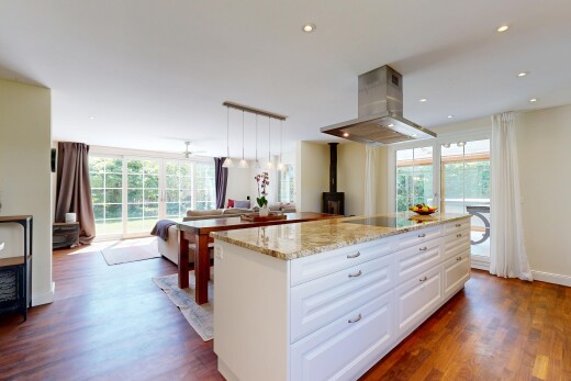 küche mit dunstabzugshaube, stone countertops, stein arbeitsplatten, opens to living area, und öffnet sich zum wohnraum