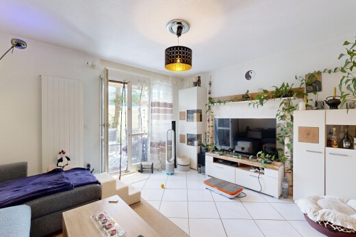 salon avec télévision, sol en carrelage, tile floor, inside property, et lumière naturelle