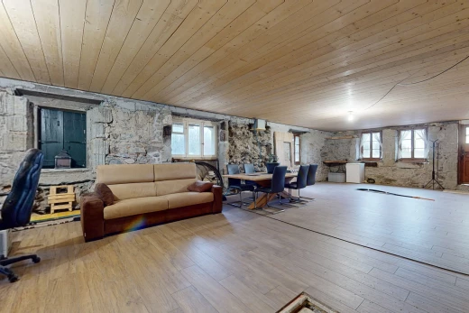 espace intérieur avec plancher de bois, mur en pierre, lumière naturelle, et plafond de bois