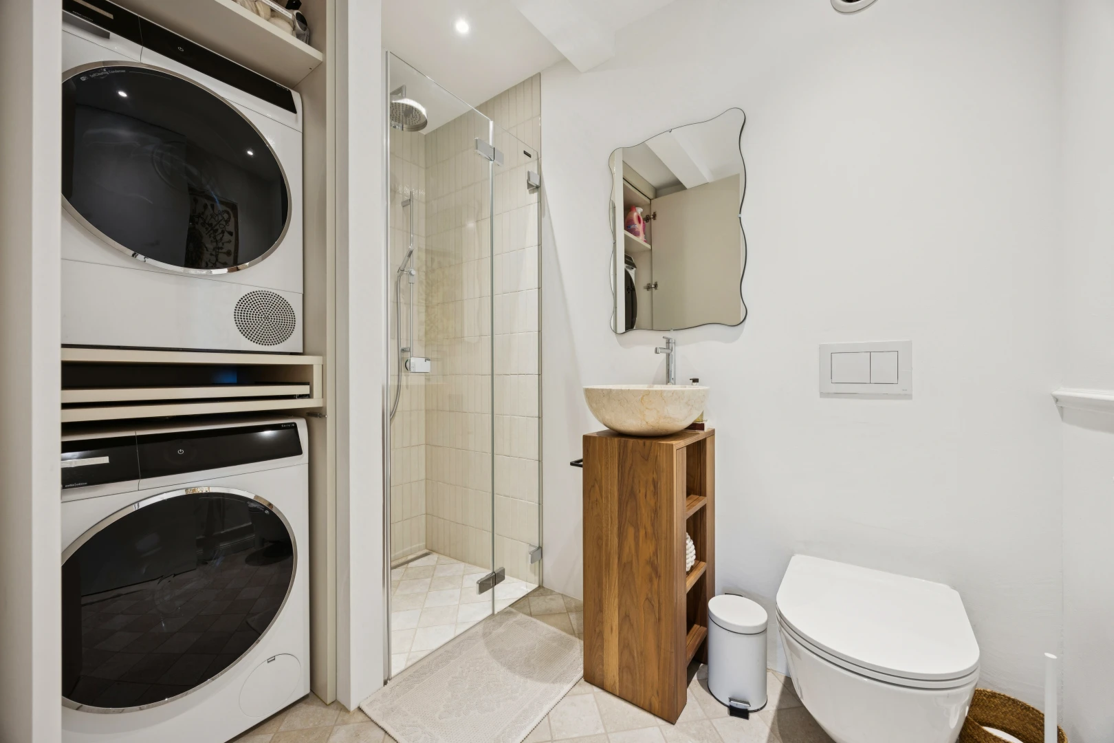 salle de bains avec douche, salle de bain complète, miroir, lave-linge et sèche-linge superposés, et drywall